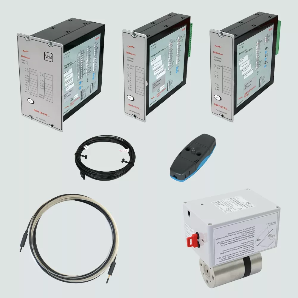 Set of electrical protection components including three control modules, coiled cables, a sensor unit, and a cylindrical actuator on a light background.